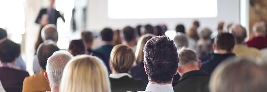 People listening to a presentation backview