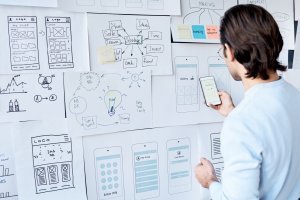 Man planning his work on papers on a wall